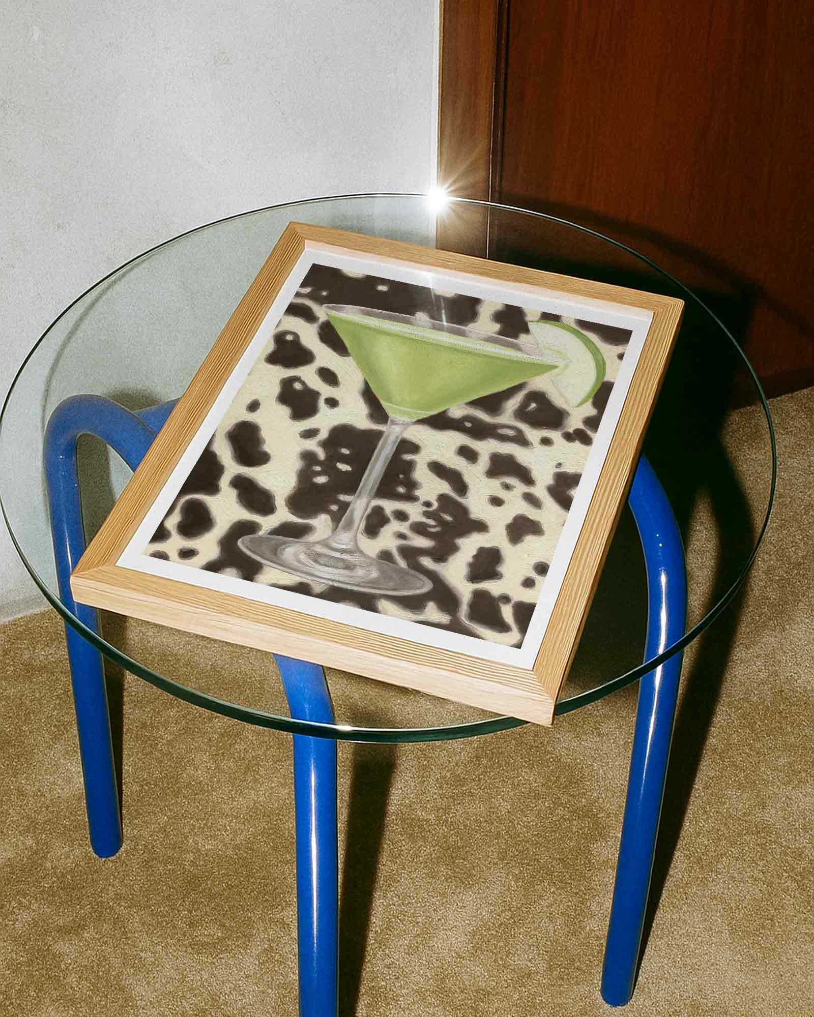 Glass table with a framed picture of a cocktail on a cow print background