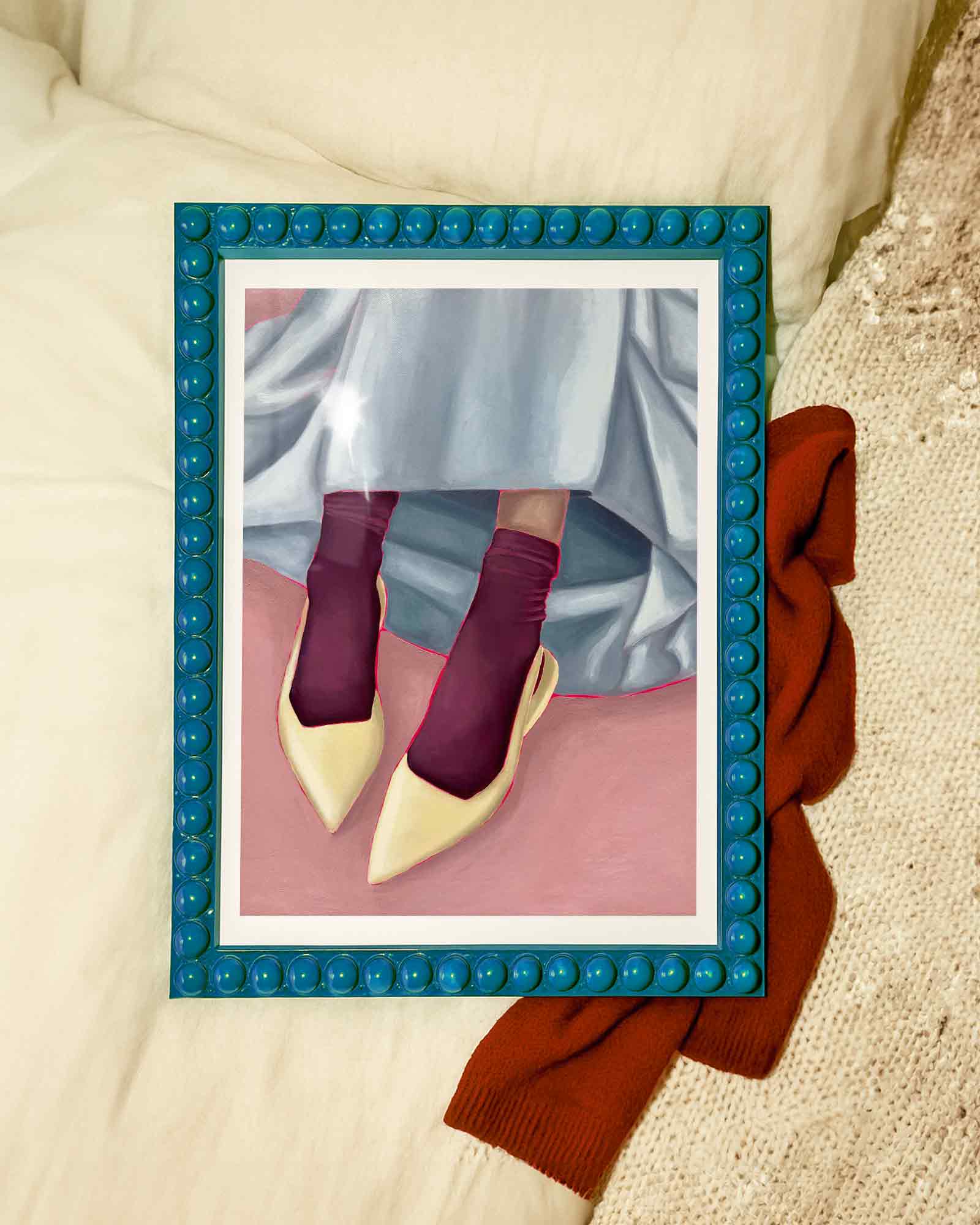 Framed art print of person wearing yellow shoes, maroon socks, and a light blue skirt on a pink background.