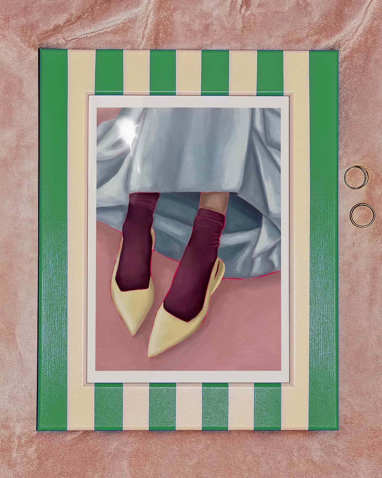 Framed art print of person wearing yellow shoes, maroon socks, and a light blue skirt on a pink background.