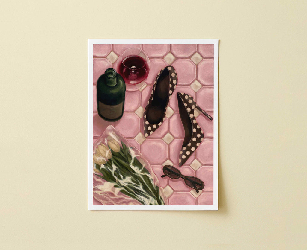 Print of pink tiled floor with a wine bottle, glass, shoes, flowers, and sunglasses