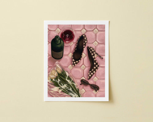 Print of pink tiled floor with a wine bottle, glass, shoes, flowers, and sunglasses
