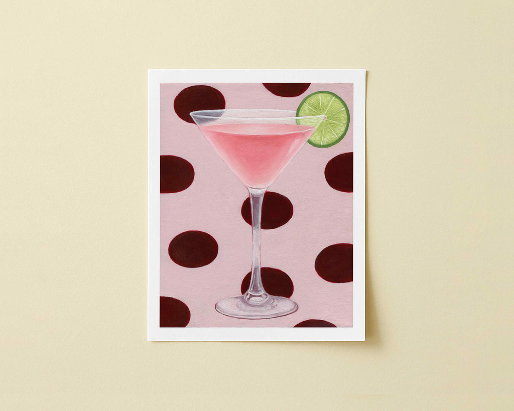 Print of a pink cocktail in a martini glass with a lime wedge on a polka dot background