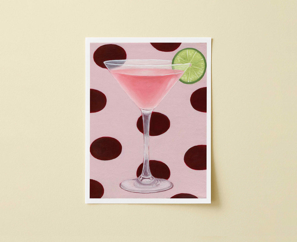 Print of a pink cocktail in a martini glass with a lime wedge on a polka dot background