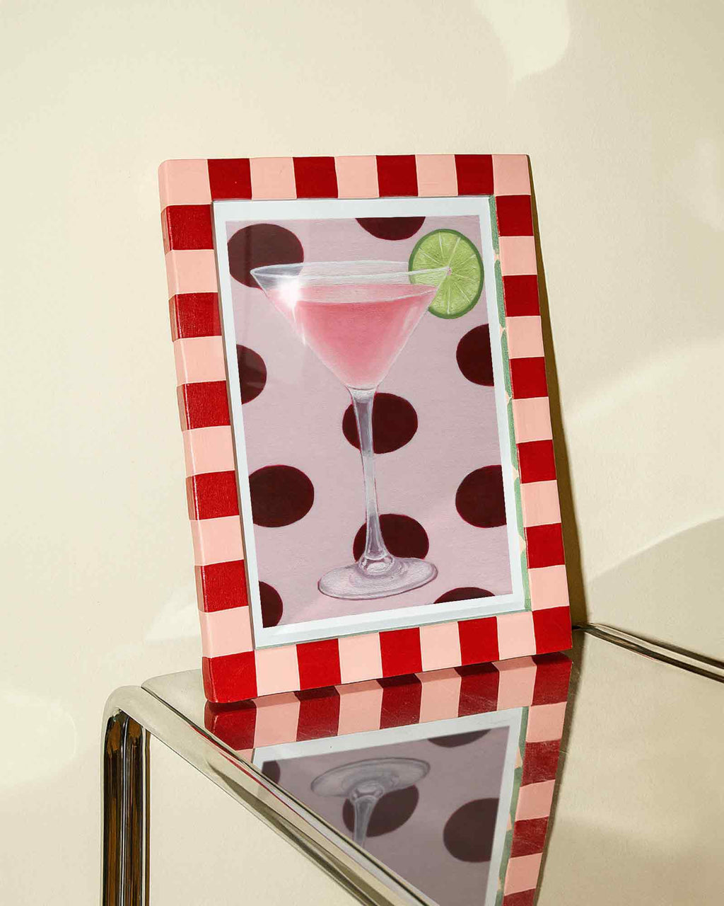 Decorative picture frame with a polka dot design on a reflective surface.