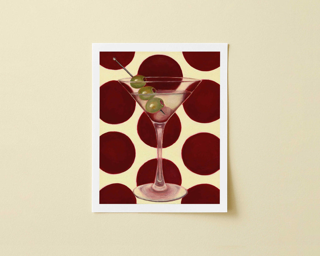 Print of a martini glass with olives on a red and beige polka dot background