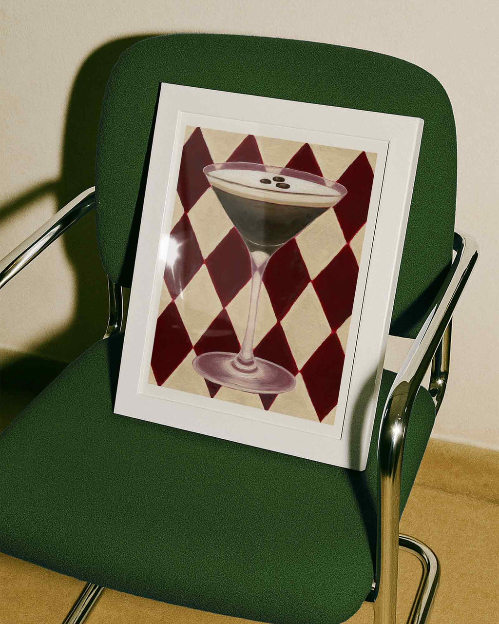 Framed artwork of a cocktail on a green chair with a checkered pattern.