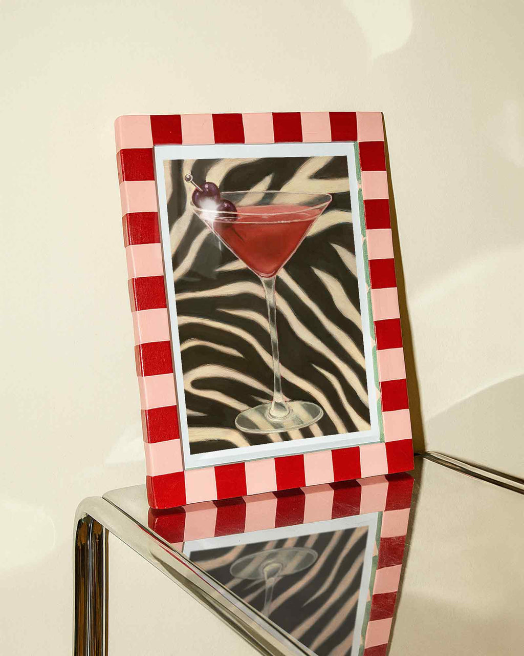 Decorative picture frame with a red and white checkered border of an orange cocktail