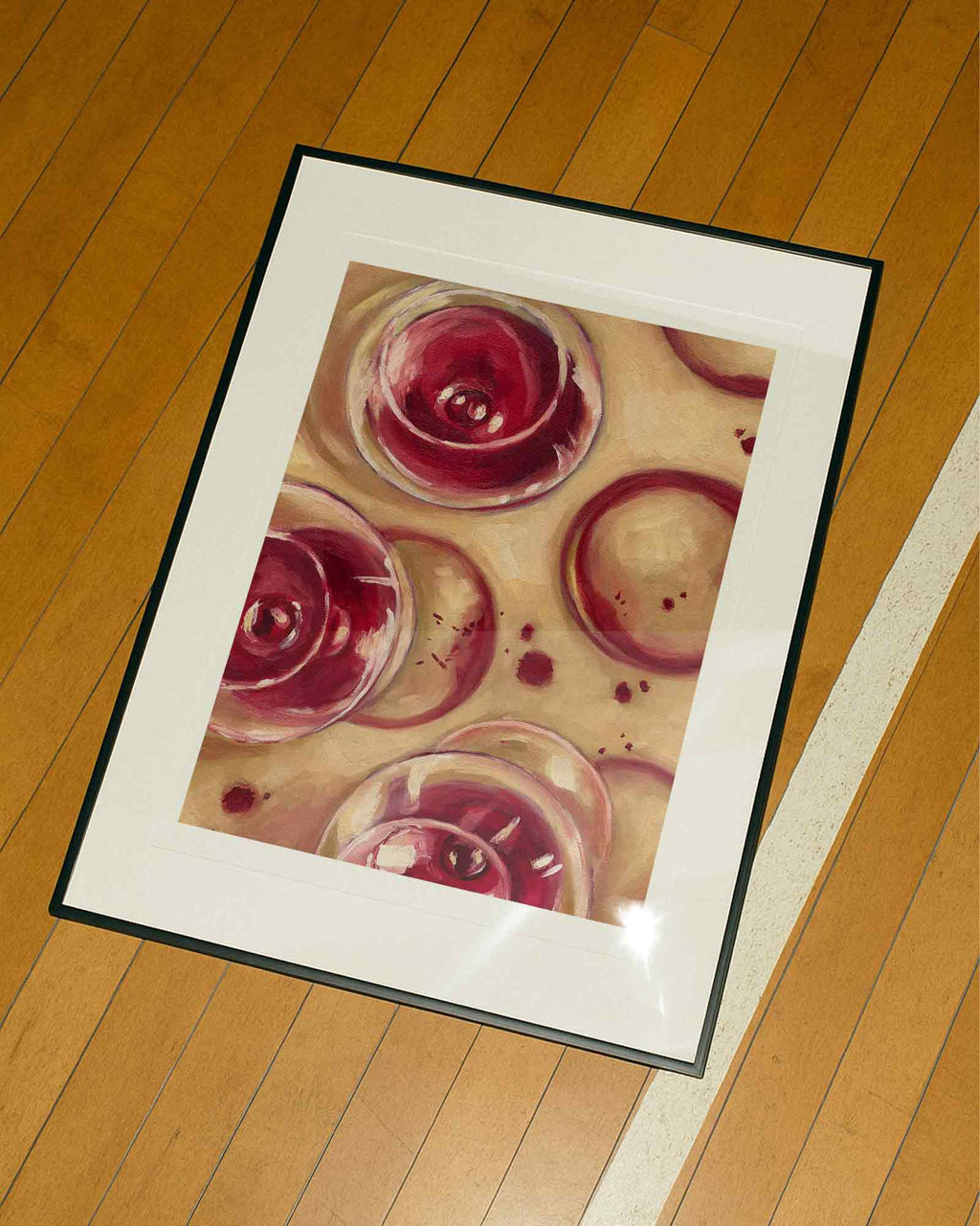Framed artwork of wine glasses on a wooden floor
